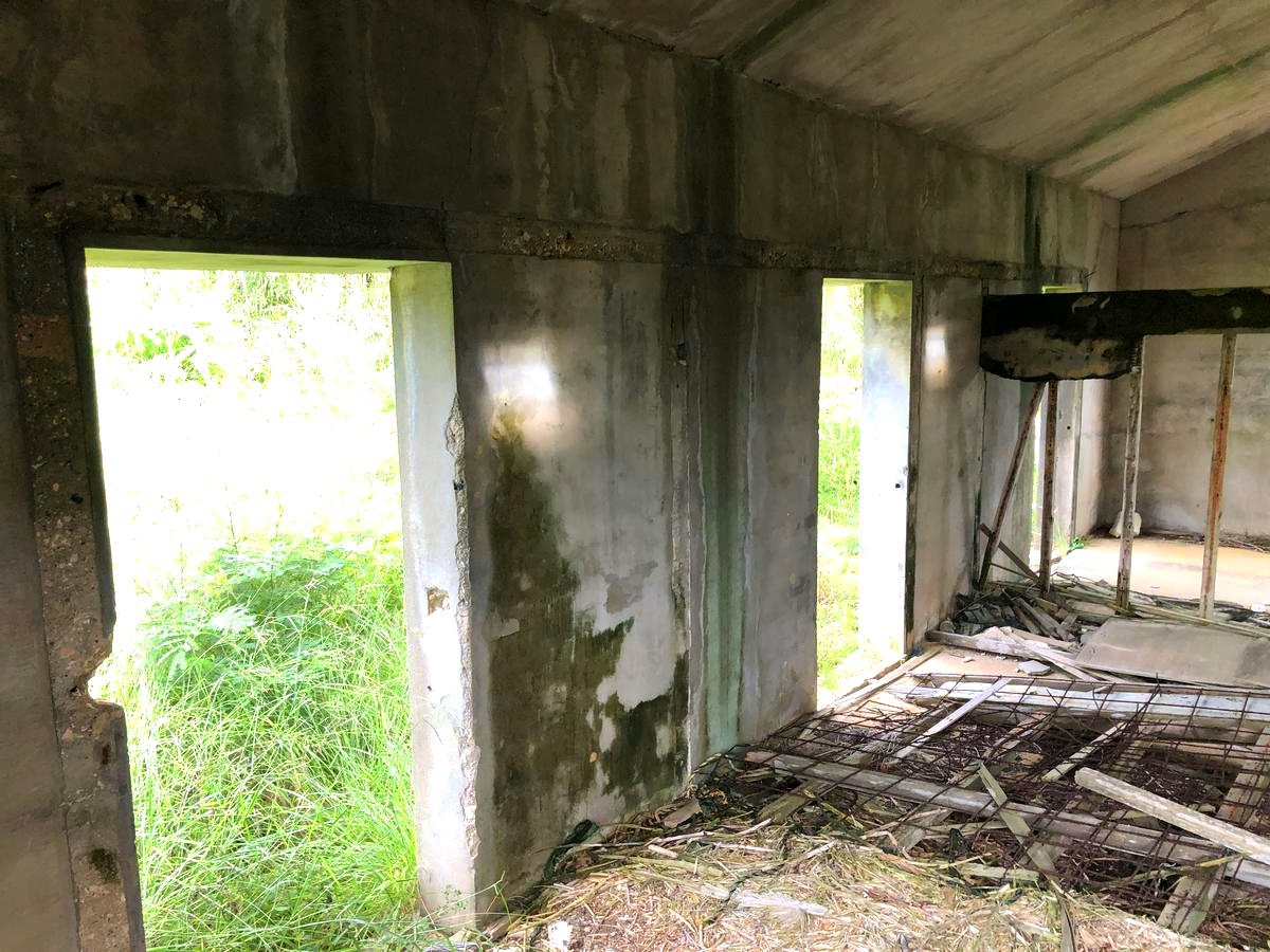 社員風呂遺構の内部を別角度から捉えた写真。ドアなどの建材はなく、出入り口にぽかんと穴が開いている。床や壁なども全て崩壊しているが、建物全体から当時の構造がうかが